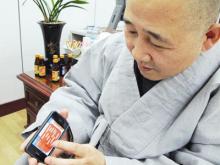 Hòa thượng Jung Ho đang mở một ứng dụng về triết lý Phật giáo trên điện thoại di động . Ảnh: Yonhap